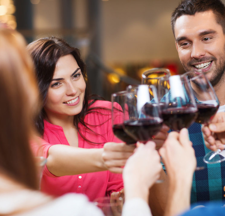 friends clinking glasses of wine at restaurant